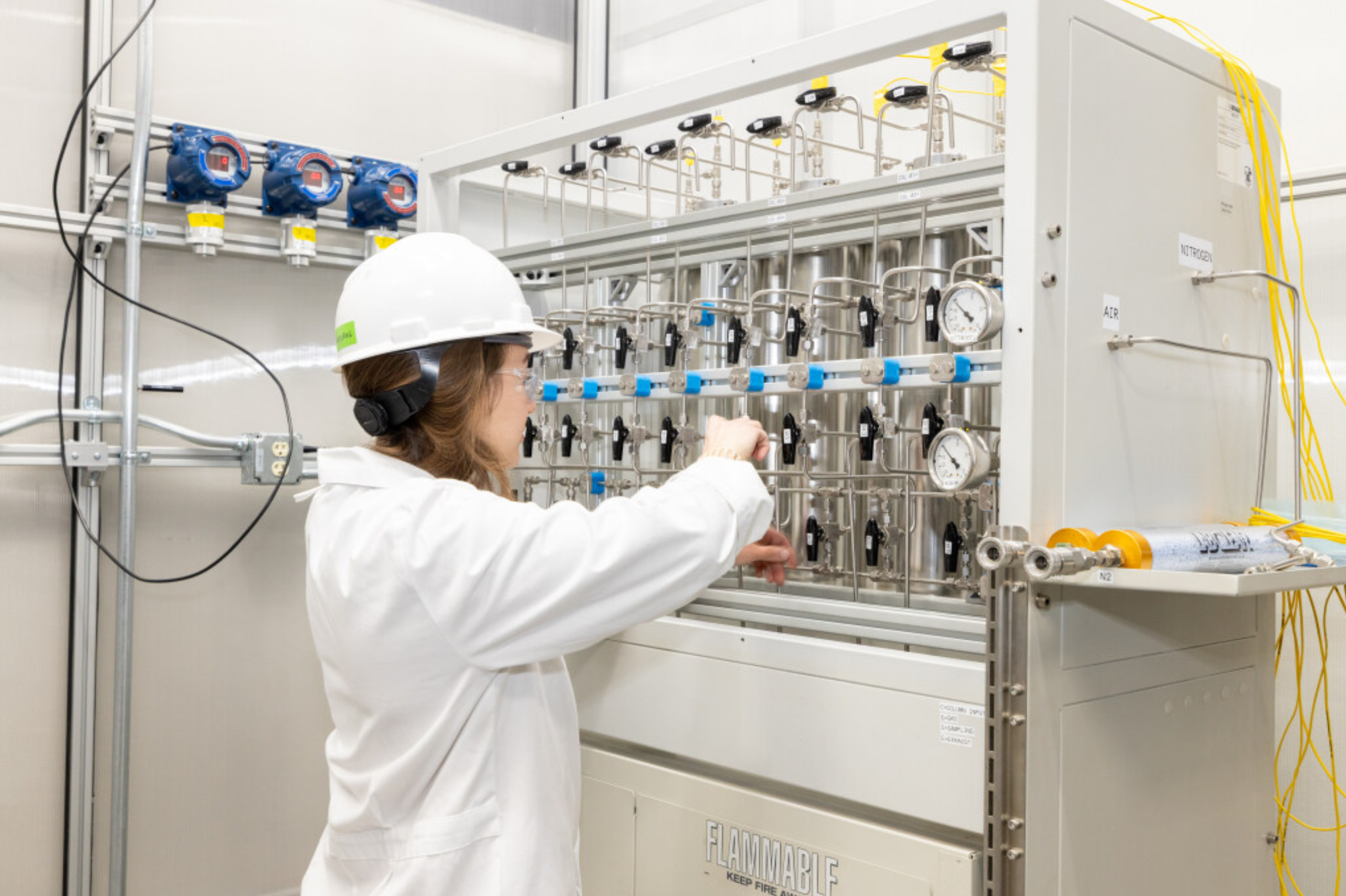 Scientist operating analytical or pilot process equipment in a clean technical facility